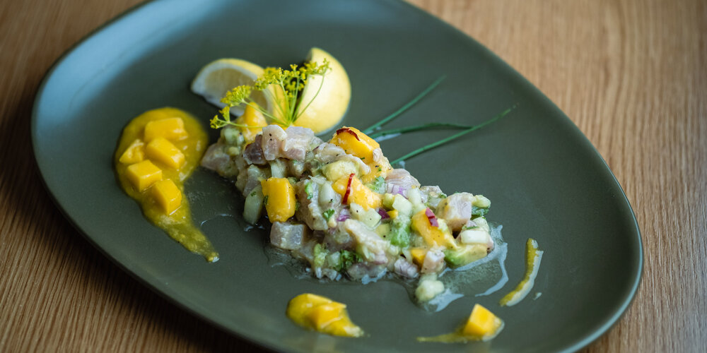 Fish ragout garnished with herbs and lemon on a plate
